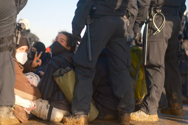 Von der Polizei umstellt blockieren Demonstrant*innen eine Zufahrt zum Tagebau Garzweiler II.