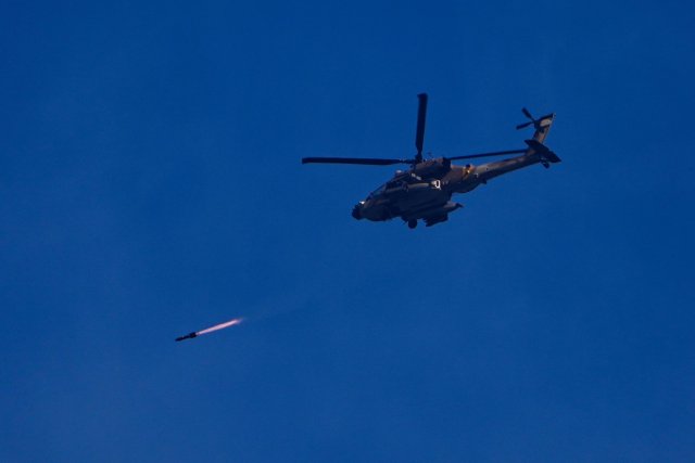 Ein israelischer Apache-Hubschrauber feuert eine Rakete in Richtung Gazastreifen ab, gesehen vom Süden Israels aus.