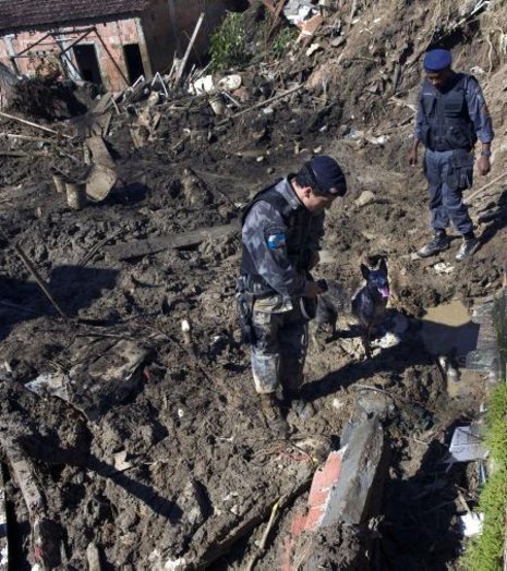 Helfer durchkämmen die Unglücksorte in den Slums. Foto: AFP