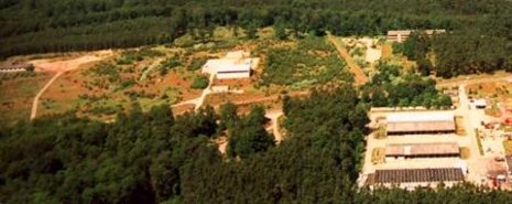 Blick auf die Anlage in Prenden 1993. Die Gebäude (siehe Pfeil) wurden abgerissen, die Zugänge verschlossen und eingeebnet.