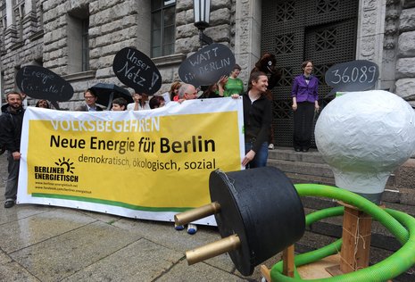 Energiegeladen: Unterschriftenübergabe mit selbstgebastelter Sparbirne vor dem Innensenat.